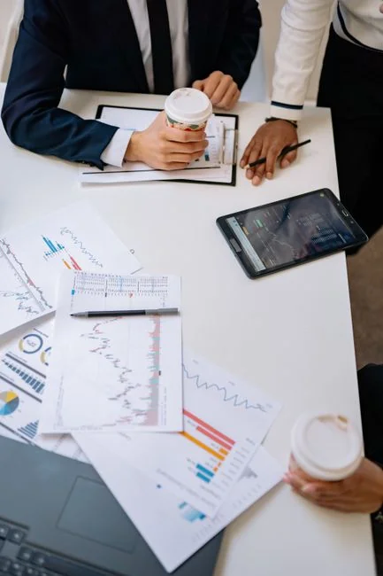Une équipe travaille sur une stratégie marketing à partir de graphiques de données et de documents, lors d’une réunion au bureau.